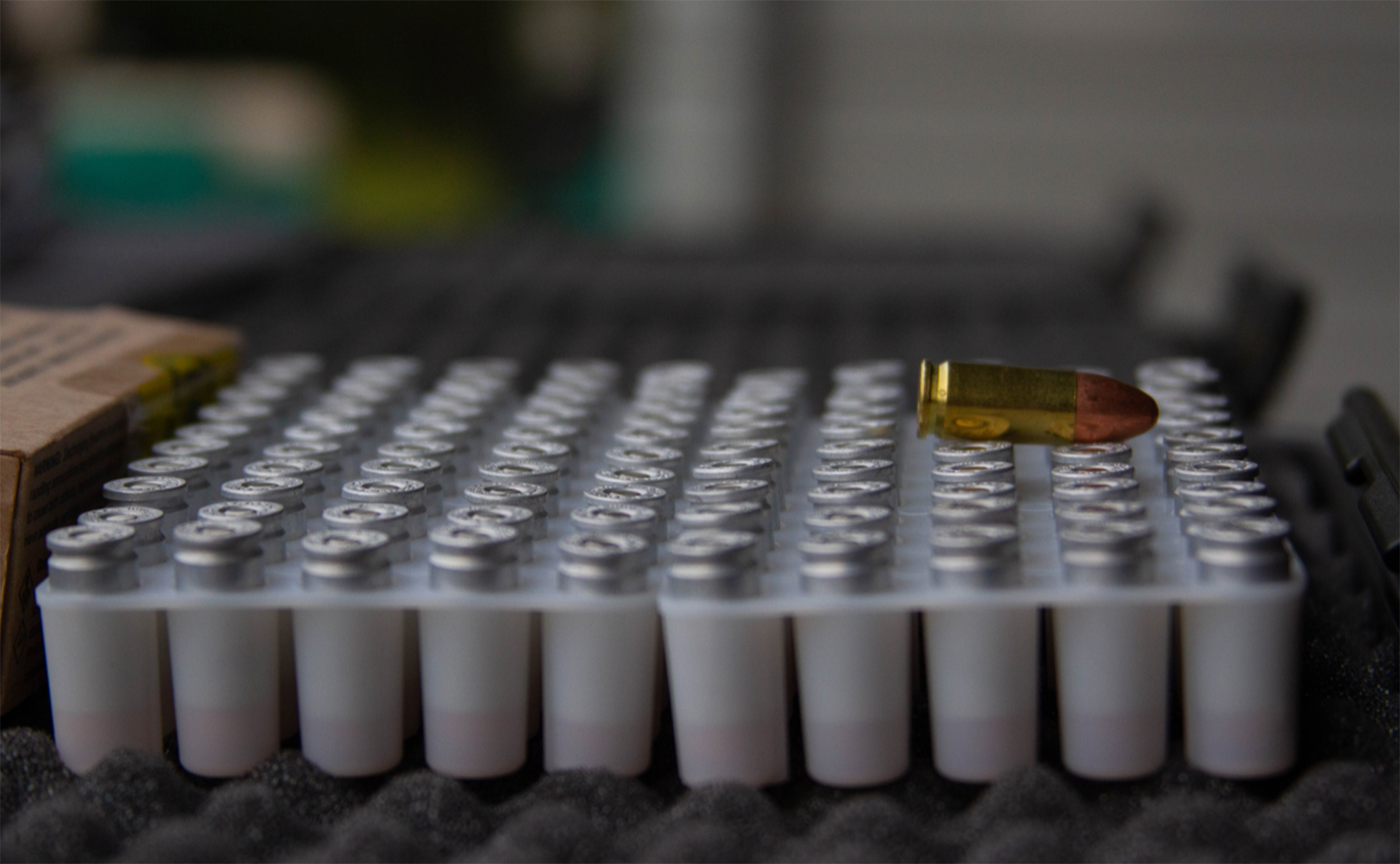 A photo of a bullet resting ontop of a handgun case.